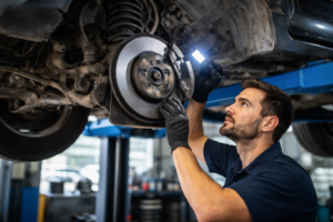Mechanic inspecting car brakes and suspension